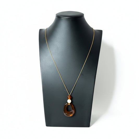 Brown Aura Knot cord necklace featuring wooden beads and an acrylic tassel.