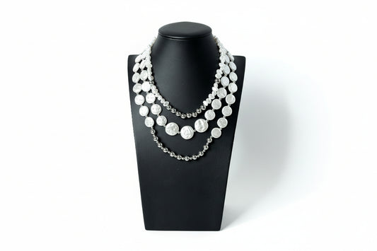 Triple strand pearl and bead layered necklace in gold and white.