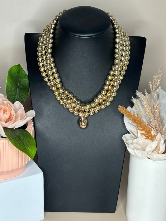 Promenade Perfection 4-layer beaded necklace and matching bracelet set in gold displayed on a pedestal mannequin.