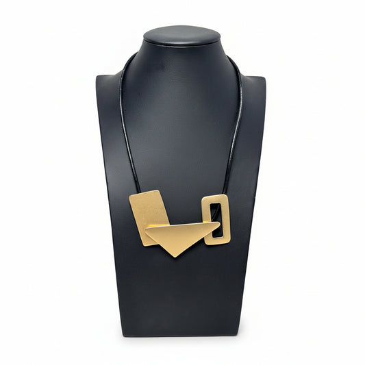 A gold-colored necklace with a leather rope chain and a gold-toned rope end, displayed on a black mannequin bust.