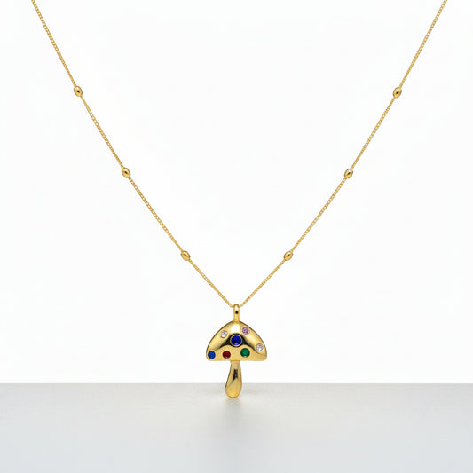 18K gold mushroom necklace displayed on a black jewelry stand.