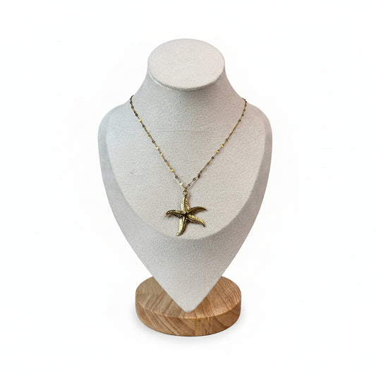 Gold stainless steel starfish pendant necklace on display.