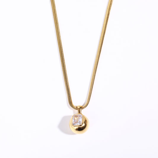 Close-up white Timepiece 18K gold plated snake chain necklace with shell inlay and colorful rhinestone.