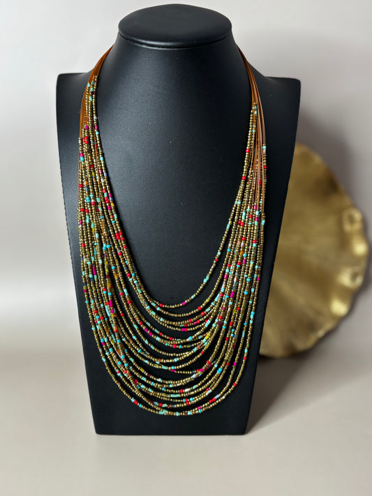 Multistrand beaded necklace on a black mannequin bust with a plain background