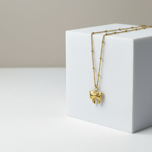 Close-up Gold Bow Chic 18K gold plated bow pendant necklace in stainless steel.