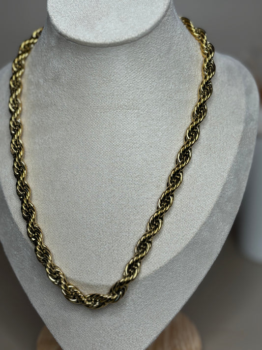 Serena twist chain necklace in 18K gold plated titanium stainless steel displayed on a mannequin. 