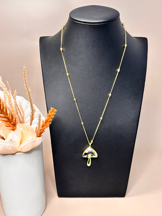 18K gold mushroom necklace displayed on a black jewelry stand.